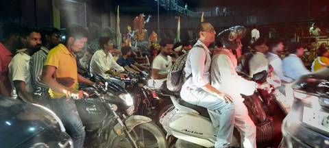 Busy street scene with people on motorbikes