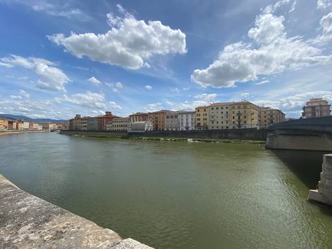 River with colorful buildings under a cloudy sky.