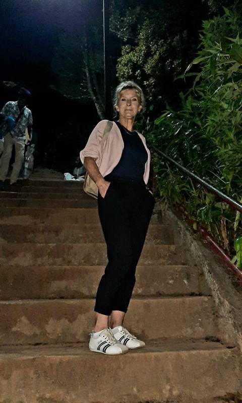       Woman standing on stairs outdoors.
  