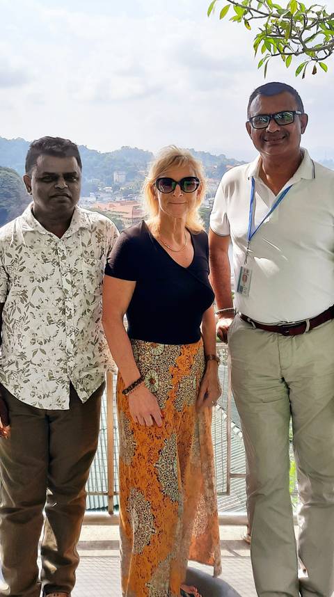 A group photo of people posing in front of a scenic view.