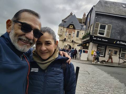 Two people posing in front of a crowded street scene.