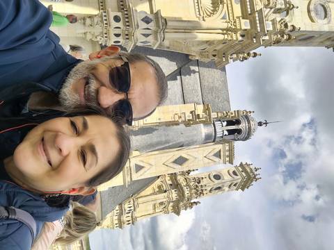 Two people posing by intricate architecture.