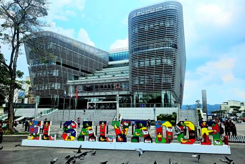 Modern building with city name sign in front.