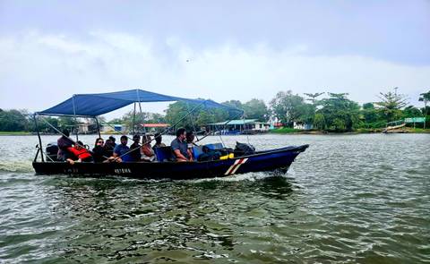 People in a boat traveling on a river.