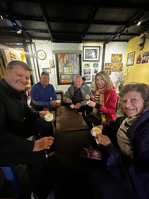 People sitting around a table enjoying hot beverages indoors.