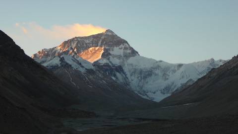 Snow-capped mountain with sunlight illuminating the peak.