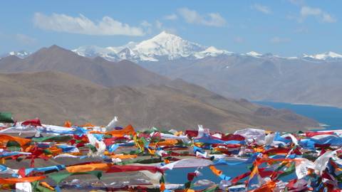 Mountains with colorful prayer flags in the foreground.