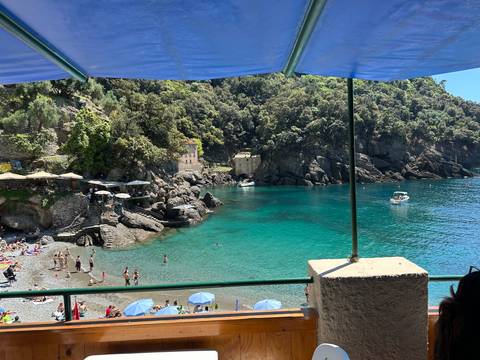       Beautiful rocky coastline with turquoise water under a sunshade.
  
