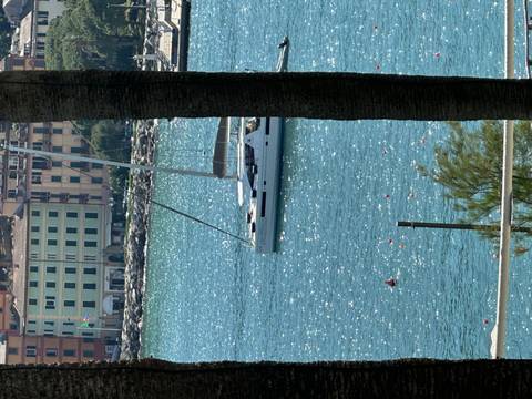 A sailboat docked near a coastal town.