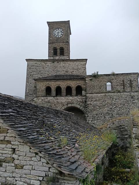 Stone building in a historic setting under cloudy skies.