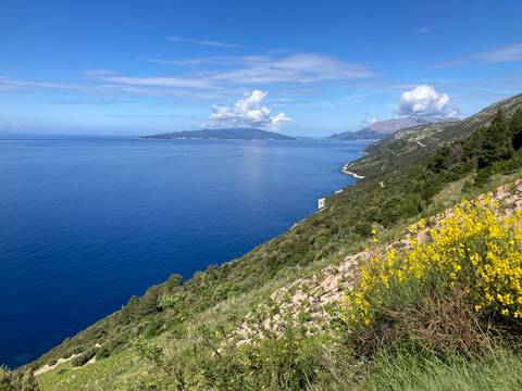       Expansive view of the coastline with blue sea and distant islands.
  