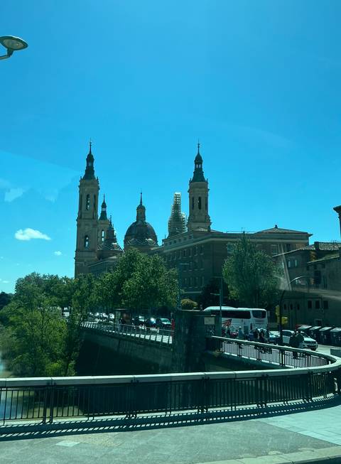 Basilica viewed from a distance with trees and cars.