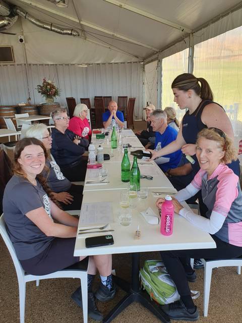       Group of people sitting at a table being served drinks.
  