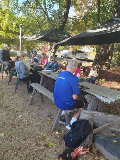 Group of people relaxing on wooden benches outdoors.