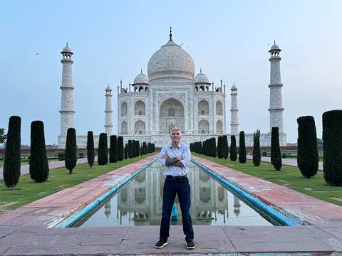 Tourist posing in front of the Taj Mahal.