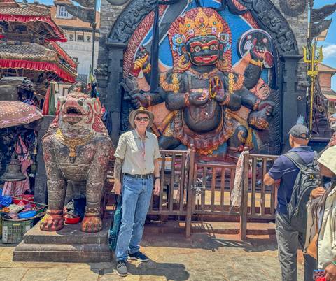 Tourist near a large ornate deity statue.