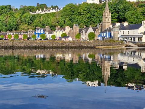       Multicolored houses along a waterfront with reflections.
  