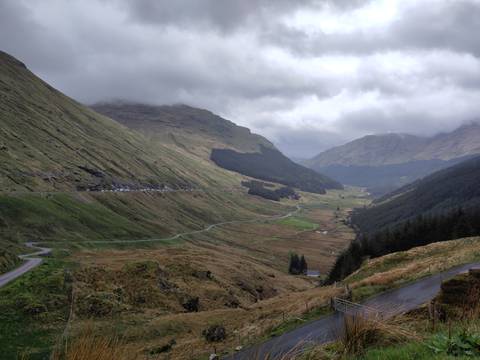       Scenic view of a lush valley with winding roads.
  