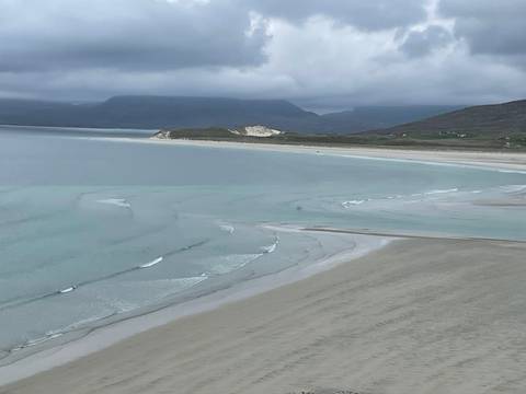 Beautiful beach with clear waters and distant hills.