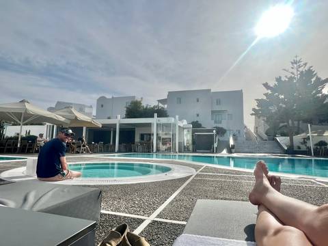 Person relaxing by a pool at a resort.