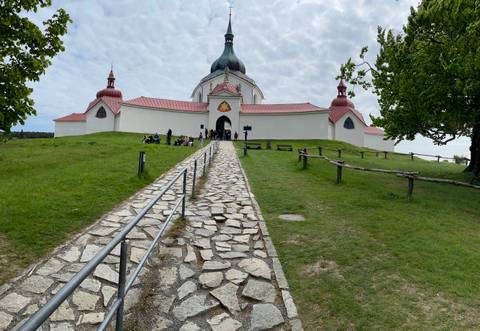 Pathway leading to a church with people sitting on the grass.
