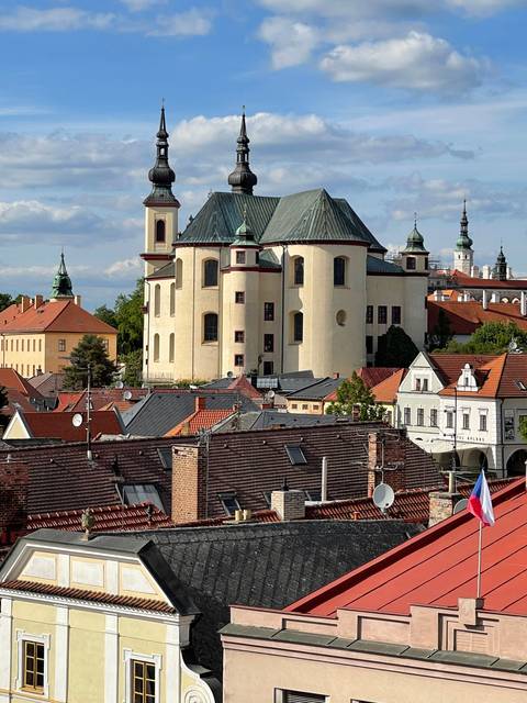 Historic church with a green dome in a town with red roofs.