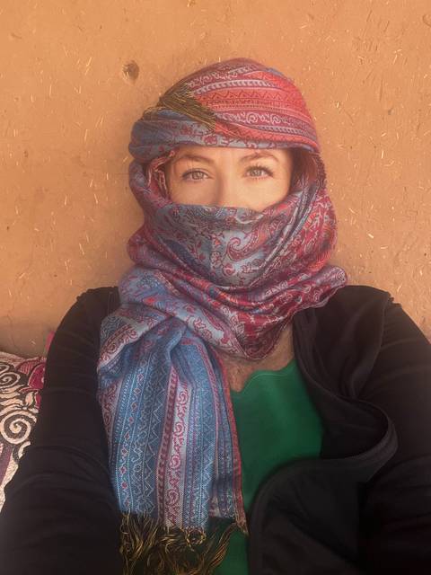 Person wearing traditional scarf with intricate patterns.