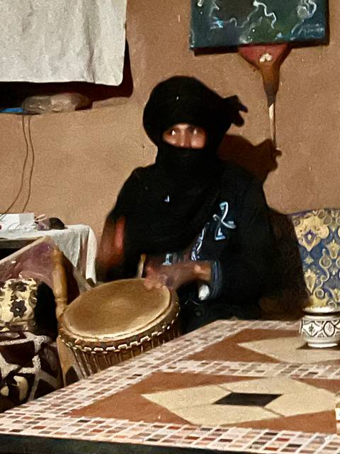Person drumming in a dimly lit room.
