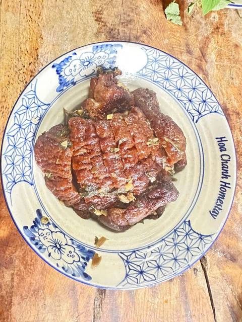 Plate of cooked meat with garnish on a ceramic plate.