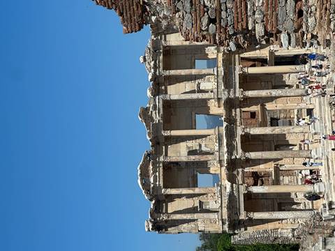       Roman ruins with columns and people walking
  