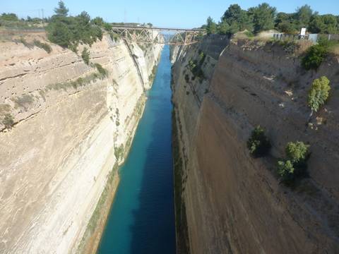Deep canal flanked by rocky walls, spanned by a bridge.