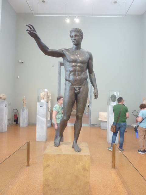 Museum with classical statues and visitors.