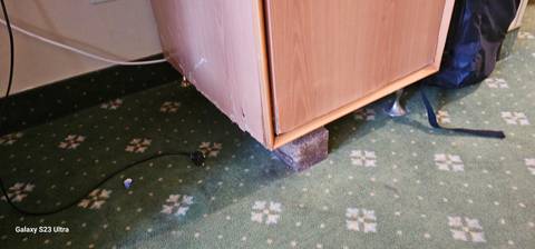 Poorly maintained furniture in a room, text watermark visible.