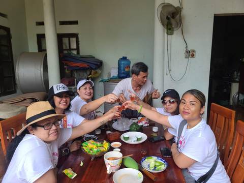       Group seated around a table raising a toast.
  