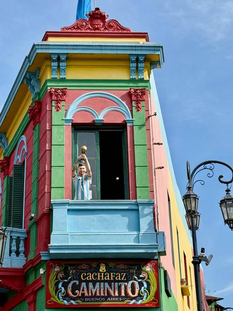A colorful building facade with a figure holding a trophy.