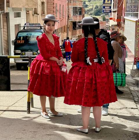       Women in traditional dresses on a street.
  