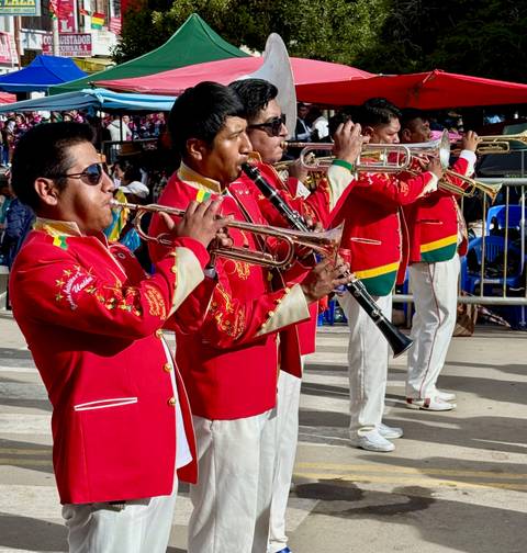       A brass band performing in bright red uniforms.
  