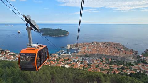       Cable car overlooking a historic coastal city.
  