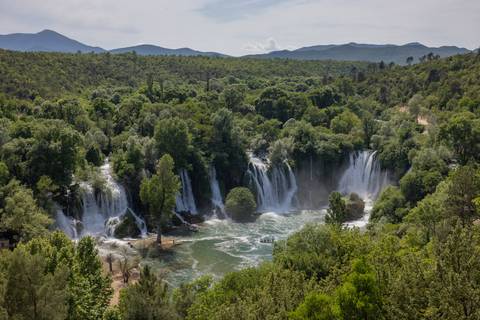       Beautiful waterfall surrounded by lush greenery.
  