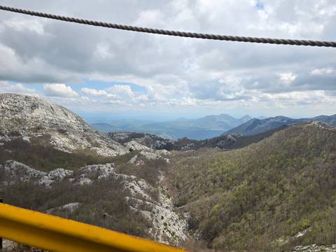       Mountain landscape with a valley view under a cloudy sky.
  