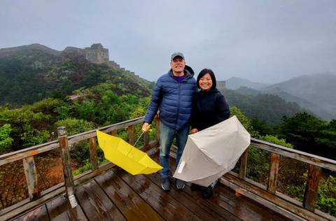       Two people with umbrellas at a scenic overlook.
  
