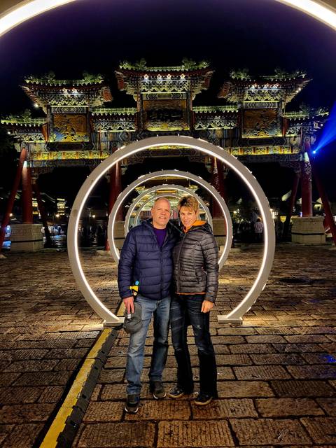       Couple standing in front of circular light installations at night.
  