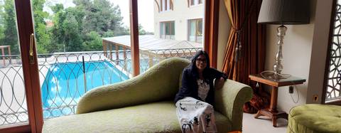       Woman sitting in a luxurious room with pool view.
  