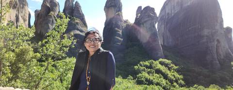       Woman posing with dramatic rock formations.
  