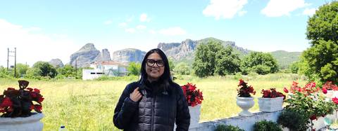       Woman posing with a scenic mountain view.
  