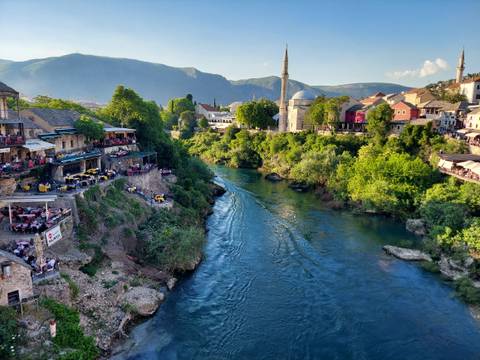Scenic river running through Mostar with buildings on either side.
