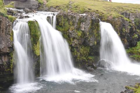 Waterfalls cascading over moss-covered cliffs.