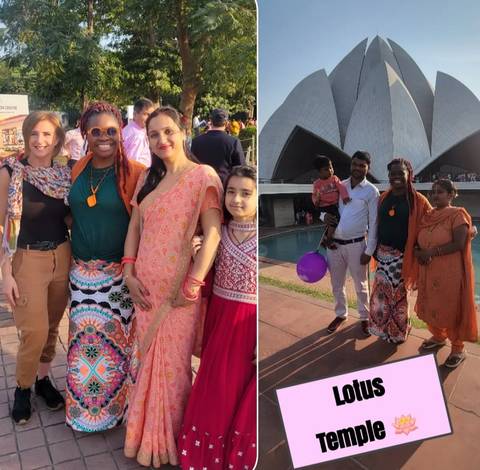       Group of people in traditional attire with a modern building in the background.
  