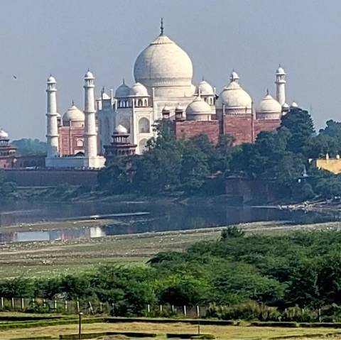       Distant view of the Taj Mahal with surrounding landscape.
  