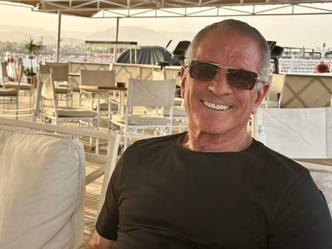 Person smiling indoors at a cafe.